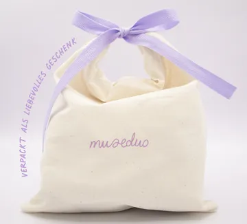Geschenktasche aus Stoff mit lila Schleife.