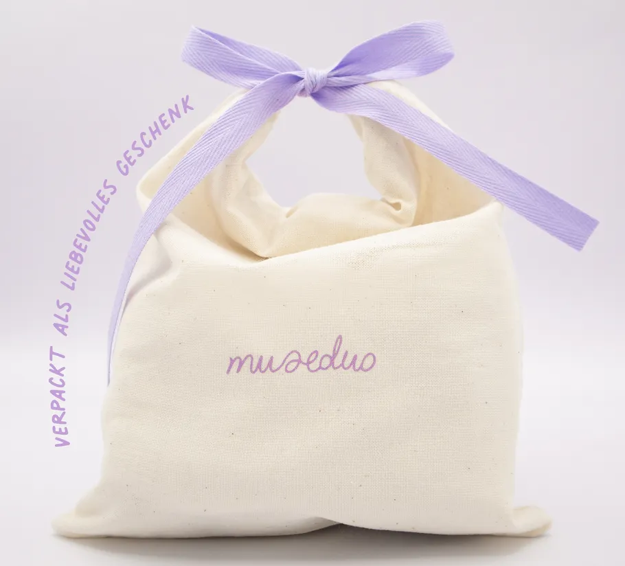 Geschenktasche aus Stoff mit lila Schleife.