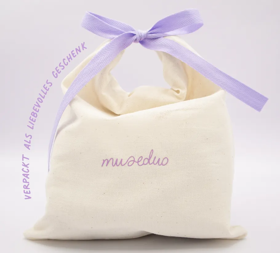 Fabric bag with purple bow and text.