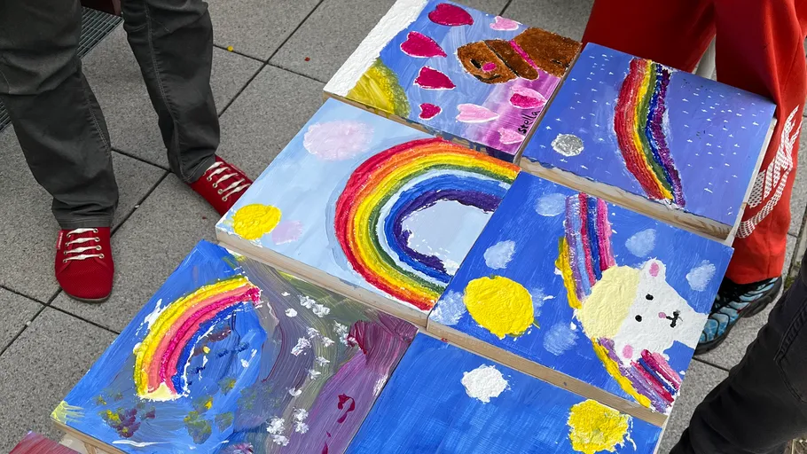 Bunte Kinderbilder auf Holzblöcken im Freien.