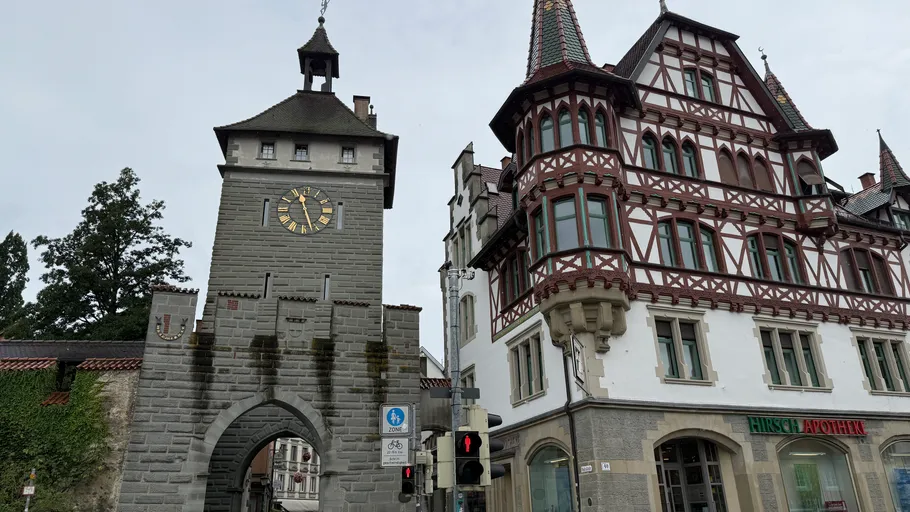 Clock tower next to traditional building, street view.