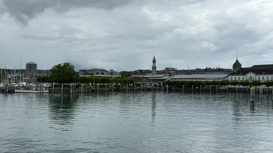 Waterfront with cloudy sky and distant buildings.