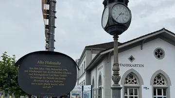 Old clock tower near white building entrance.