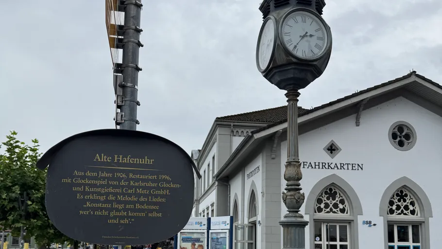 Old clock tower near white building entrance.