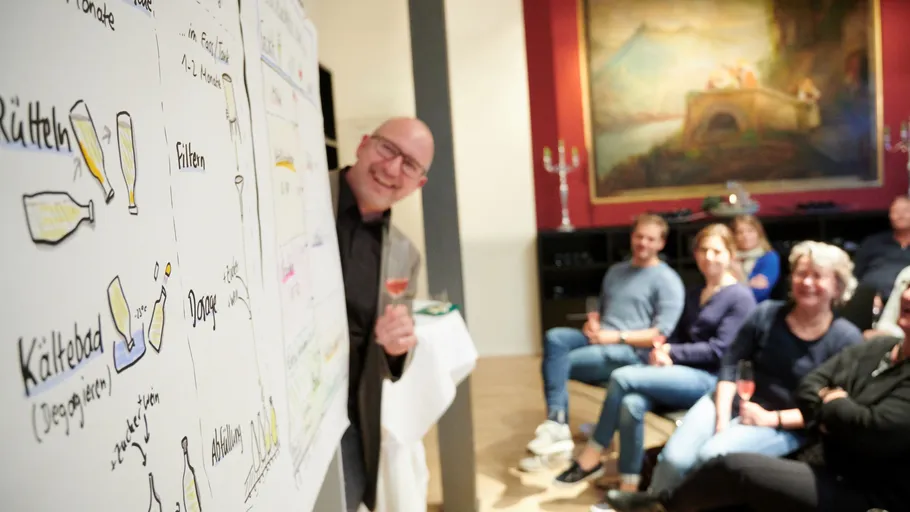 Man presenting diagrams to seated audience.