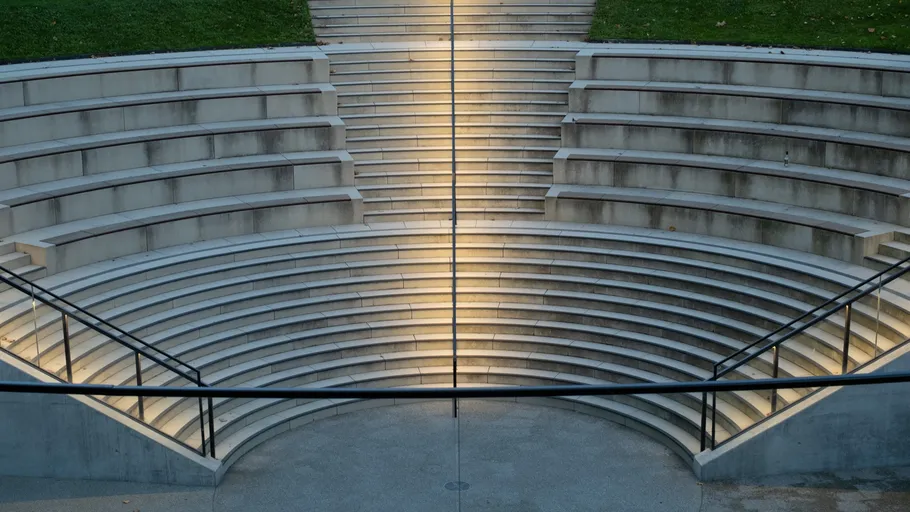 Leeres Amphitheater mit gestuften Betonsitzen.