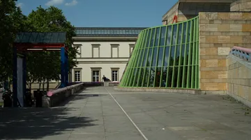 Schräge grüne Fenster an Gebäudeaußenseite.