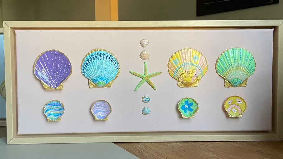 Decorative shells and starfish in a wooden frame.