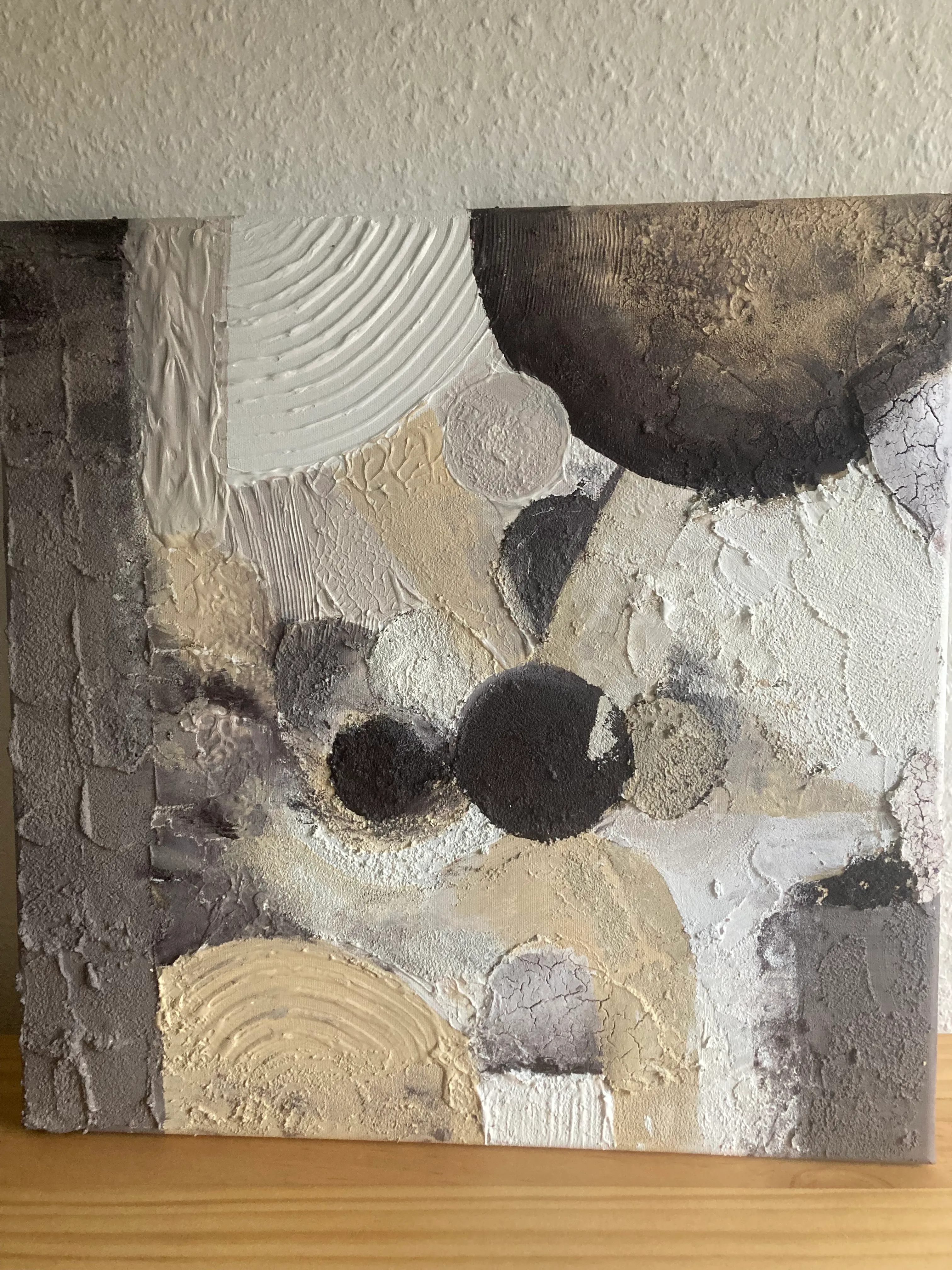Abstract textured painting with circular patterns.