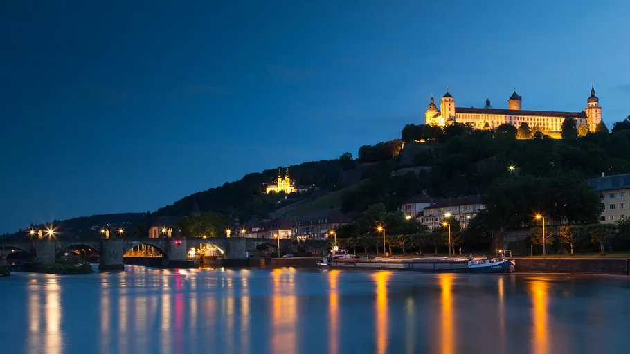 River view with illuminated castle at night.