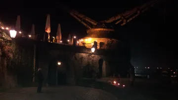 Historischer Kran beleuchtet bei Nacht, Flussansicht.