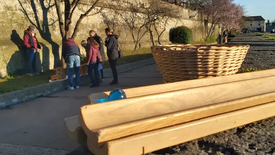 Wooden tracks and marbles outdoors.