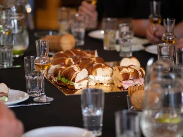 A set table with a large roll platter and drinks.