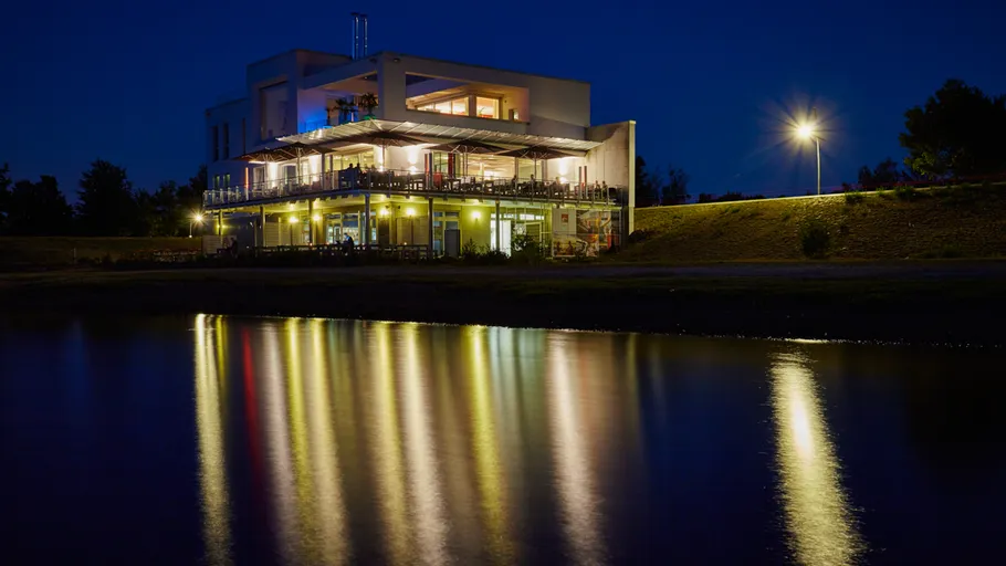 Illuminated building reflecting in night waters.