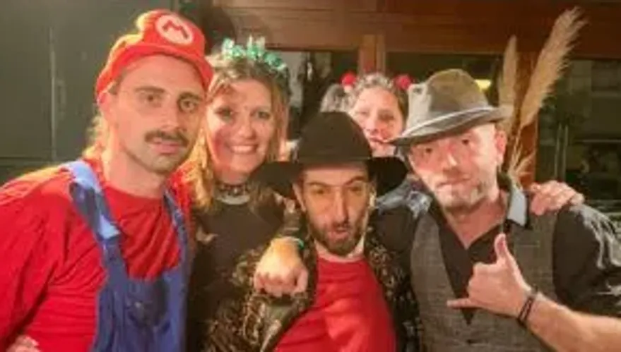 People in costumes posing indoors at a party.