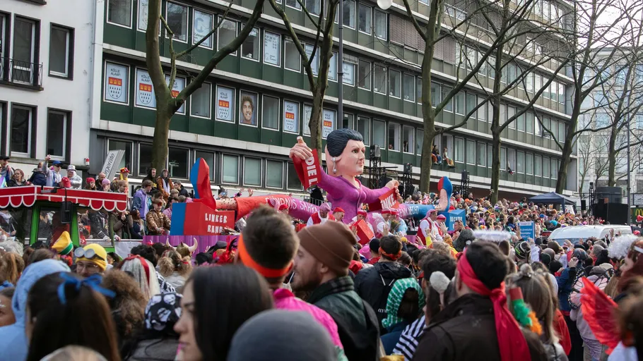 Parade float with large figure, crowded street.