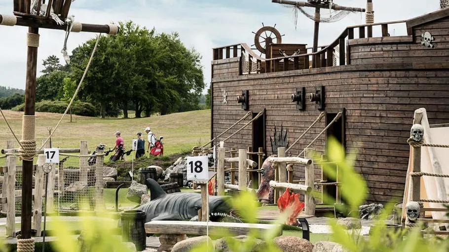 Pirate-themed mini-golf course with ship and props.
