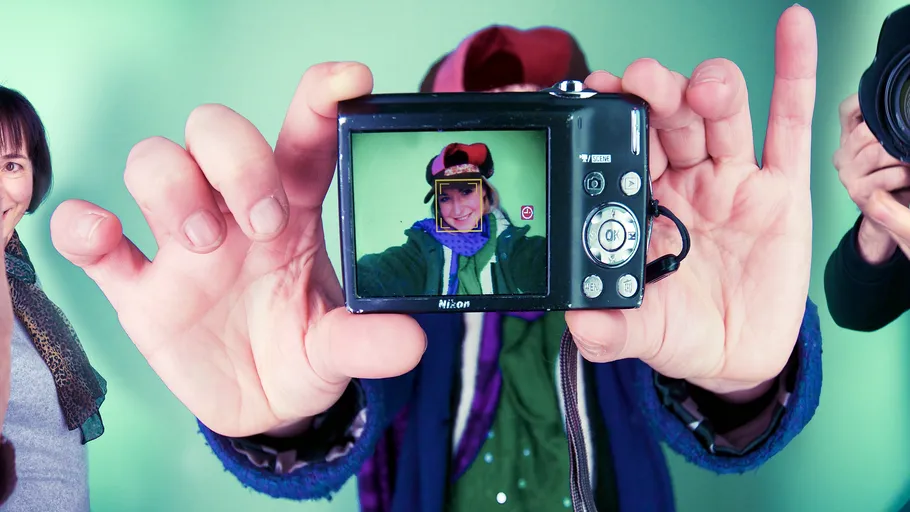 Person holding camera, image on screen visible.