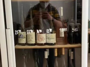 bottle of wine in a refrigerator with price tags.