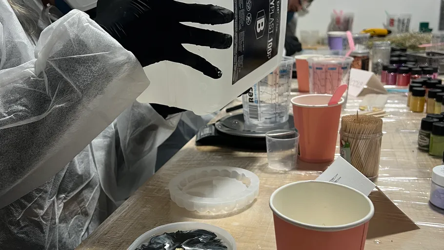 Person mixing resin at a crafting table.