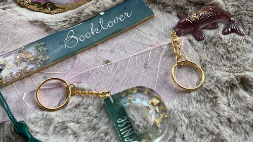 Keychains and bookmark on textured cloth.