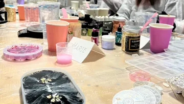 Bastelmaterialien auf einem vollen Tisch.