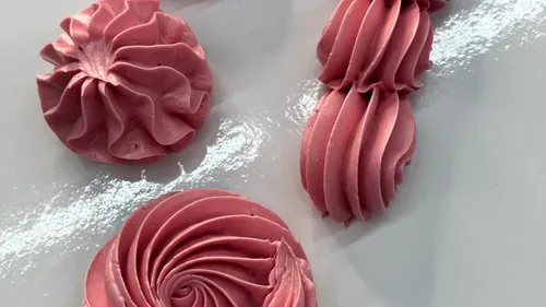 Pink frosting designs on white surface.