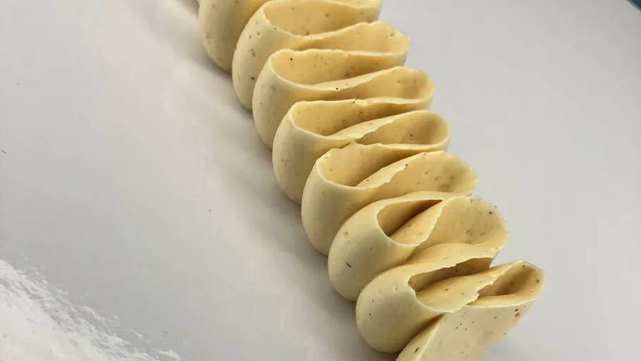 Geschnittene cremefarbene Butter auf weißem Hintergrund.