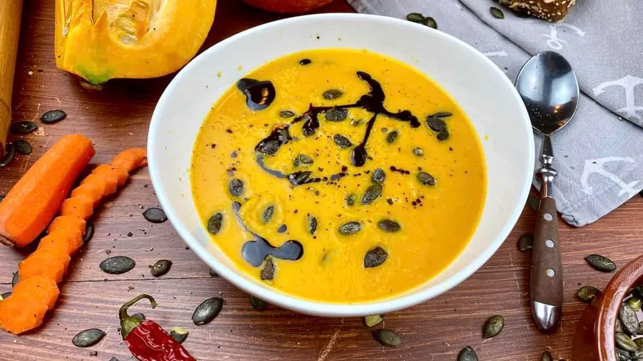 Pumpkin soup in a bowl with seeds.