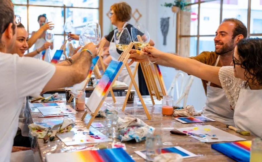 Menschen malen und stoßen im Kunststudio an.