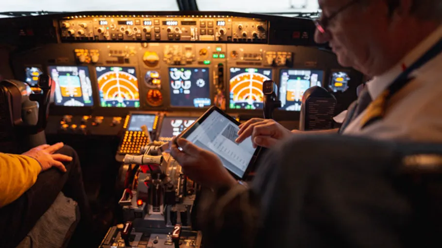 Pilot using tablet in airplane cockpit.