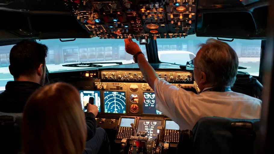 Pilots operating airplane cockpit, focused environment.