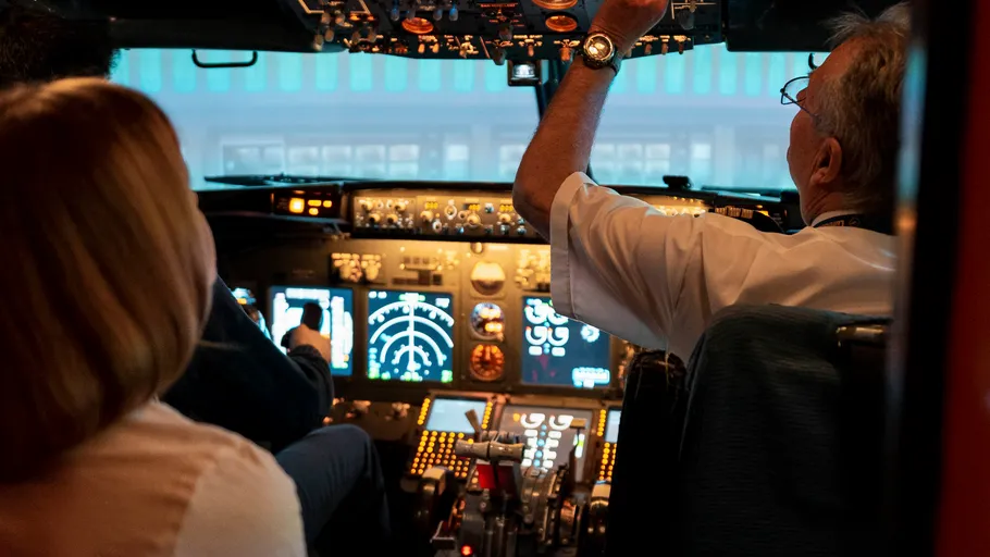 Pilots in cockpit operating an airplane.