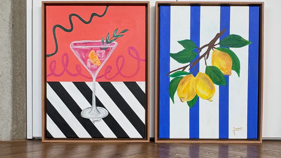 Zwei gerahmte bunte Gemälde auf Holzboden.