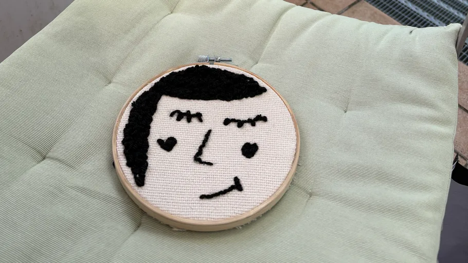 Stickerei eines lächelnden Gesichts auf Kissen.