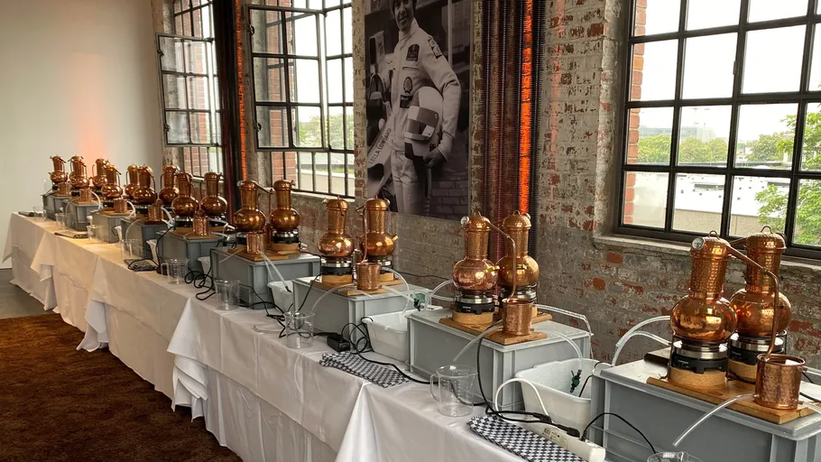 Row of copper stills in an industrial setting.