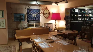 Esszimmer mit Holztischen und Gläsern.