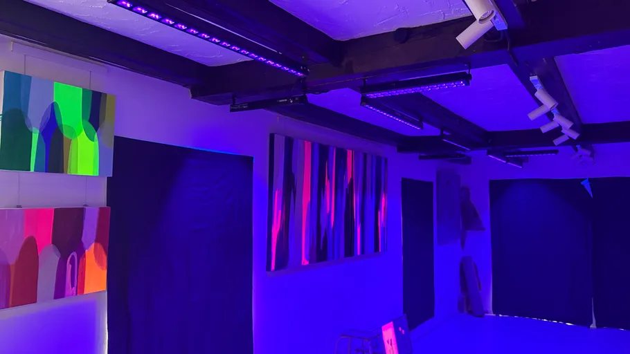 Bunte Gemälde beleuchtet von lila Lichtern im Galerie.