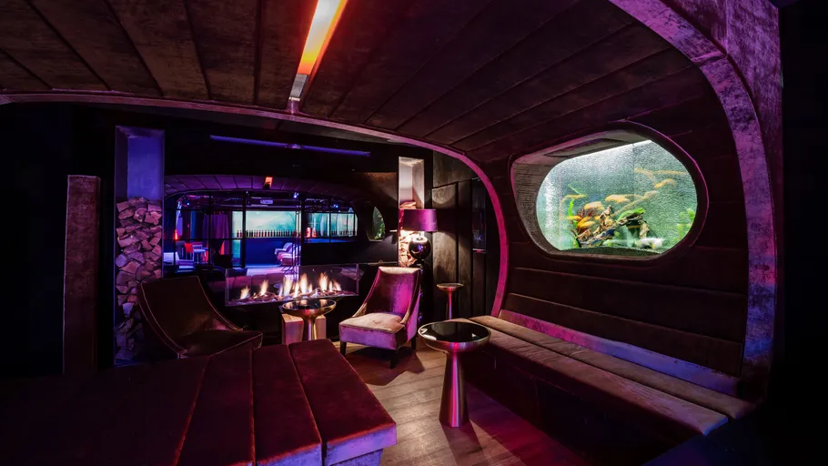 Lounge with seating, fireplace, and aquarium.