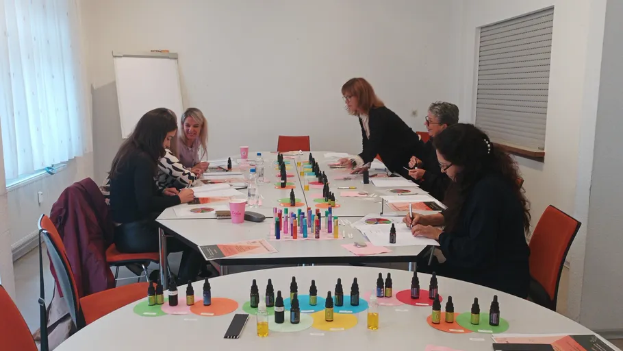 People crafting scents at workshop table.