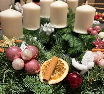 Adventskranz mit Kerzen und festlichen Dekorationen.