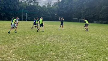 People playing rugby on a grassy field.