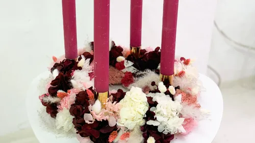 Four red candles in a floral wreath.