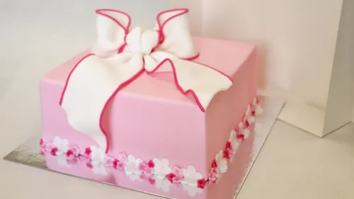 Pink cake with white bow decoration.