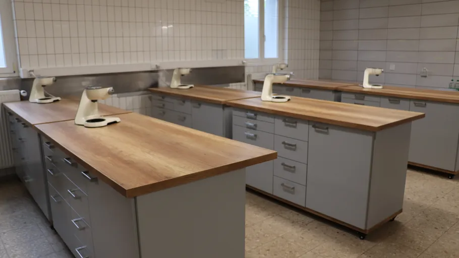Laboratory with microscopes on wooden tables.