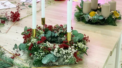 Decorative wreaths with candles on a table.