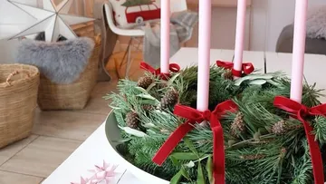 Advent wreath with pink candles on table.