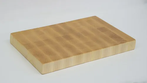 Holzschneidebrett auf weißer Fläche.