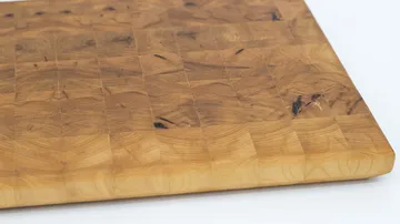Wooden cutting board on white surface.