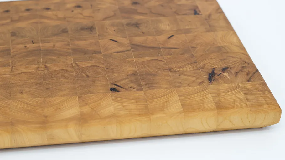 Holzschneidebrett auf weißer Oberfläche.